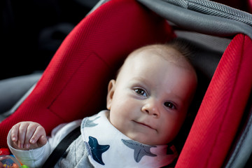 Wall Mural - Little baby boy and his older brother, traveling in car seats, going on a holiday