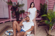 © kanashkin - Beautiful man and girl in white T-shirts near the beach house. Mock-up.