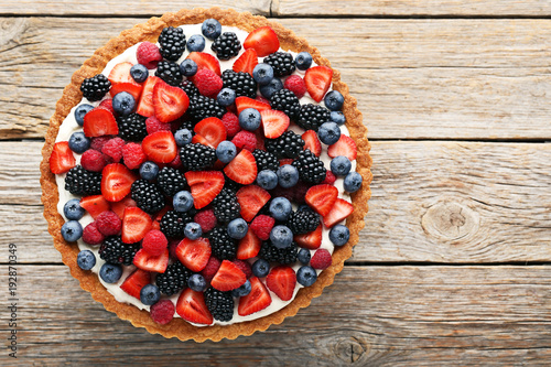 Fotografía Sweet tart with berries on grey wooden table