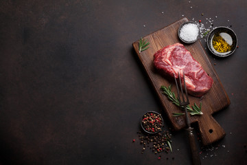 Raw ribeye beef steak cooking with ingredients