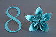 © detry26 - Paper flower from origami with the number eight on a gray background. March 8, International Women's Day.
