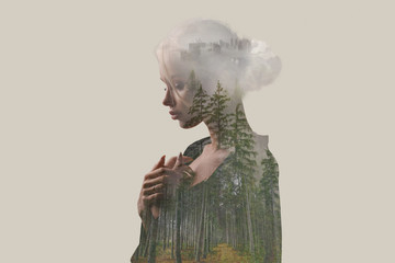 Double exposure. Creative. Beautiful girl with a forest and trees inside the body. Gray background