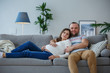 © Sergey - Picture of happy pregnant woman and man on gray sofa