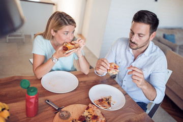 Poster - Young couple enjoying eating pizza.