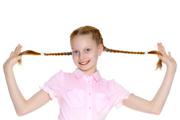 The little girl is pulling herself in pigtails.