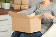 © Africa Studio - Woman opening parcel box at home