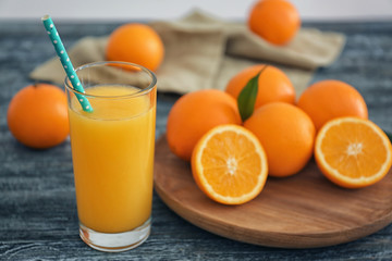 Wall Mural - Glass with fresh orange juice and fruit on wooden table