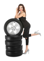 Wall Mural - Young woman in seductive outfit with car tires on white background