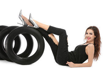 Wall Mural - Young woman in seductive outfit with car tires on white background