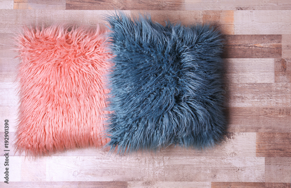 Two fluffy pillows on wooden floor
