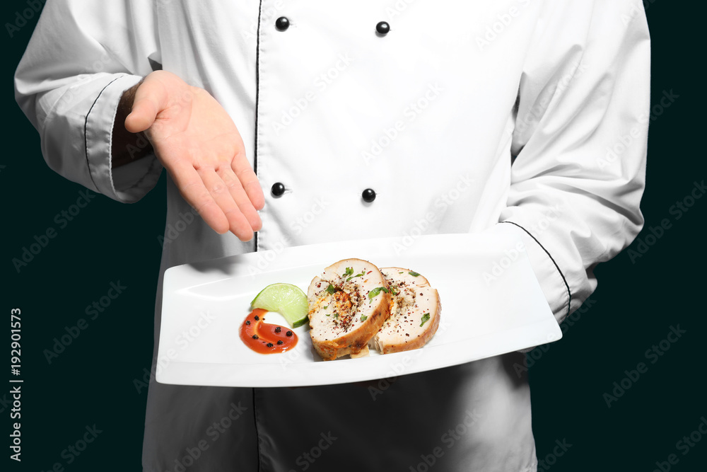 Male chef holding plate with tasty dish, closeup