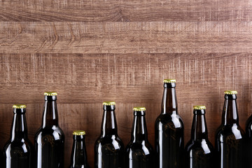 Wall Mural - Fresh beer in glass bottles on wooden background