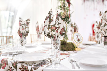 Interior of a wedding tent decoration ready for guests. Served round banquet table outdoor in marquee decorated flowers and silk. Catering concept