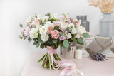 Fototapeta Koty - beautiful luxury bouquet of mixed flowers on pink table. the work of the florist at a flower shop. Wedding