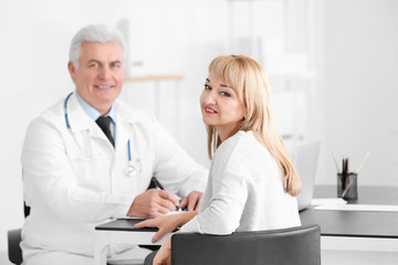 Poster - Male doctor consulting patient in clinic