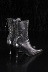 Canvas Print - black leather boots on a black isolated background