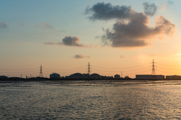 Wall Mural - Oil refinery light river front reflection at twilight, industrial landscape background