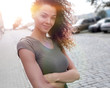 © ASDF - Young woman with afro hairstyle smiling in urban background