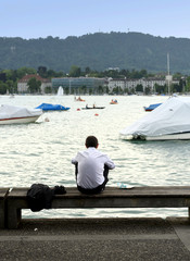 Wall Mural - Man on quay Lake Zurich. Daily life in Zurich.