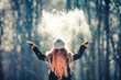 canvas print picture - Young girl throwing snow in the air at sunny winter day, back view