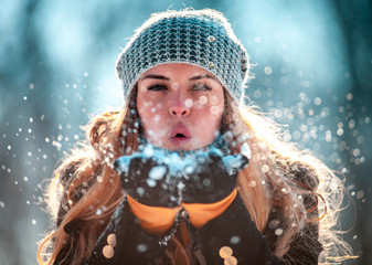 Wall Mural - Winter woman blowing snow outdoor at sunny day, flying snowflakes