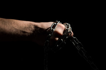 Wall Mural - Hands are chained in chains isolated on black background