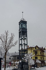 Facade of the snowy town  clock tower in winter, Bankya town, Sofia, Bulgaria  