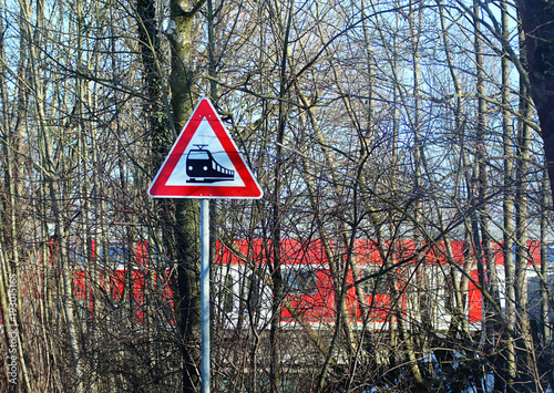 Fotografia, Obraz railroad level crossing sign on rural road and train traveling across