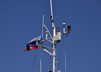 Mast of the port service ship. Devices of light signaling and communication antenna