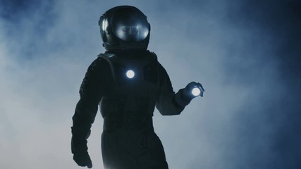 Wall Mural - courageous astronaut in the space suit holds flashlight and explores mysterious alien planet covered