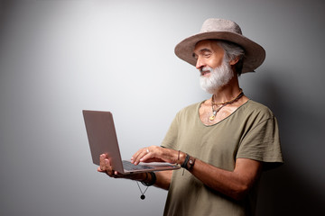 Canvas Print - Studio portrait of handsome senior man using laptop.