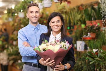 Wall Mural - Young people with flowers in greenhouse. Small business owners