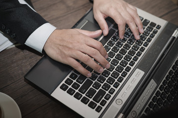 Poster - Young Asian businessman working with a laptop in a coffee shop. Top view