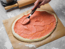 Cooking Pizza. Dough With Tomato Sauce. Woman Hands