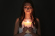 © Africa Studio - Beautiful young woman with burning candle in darkness