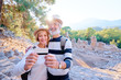© luengo_ua - More opportunities for travel. Senior traveling couple holding credit card while standing on ancient sightseeing background.