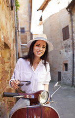 Canvas Print - Young beautiful italian woman sitting on a italian scooter.