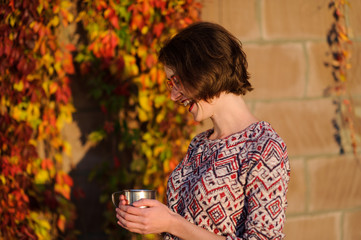 Happy young woman in park on sunny autumn day.