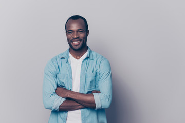 Portrait with empty place, copy space of sexy, virile, stunning man with beaming smile having his arms crossed, looking at camera, isolated on grey background