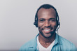 Close up portrait of cheerful positive smart clever friendly guy wearing casual clothing using headphones for working isolated on gray background, always ready to help you and give answers to question