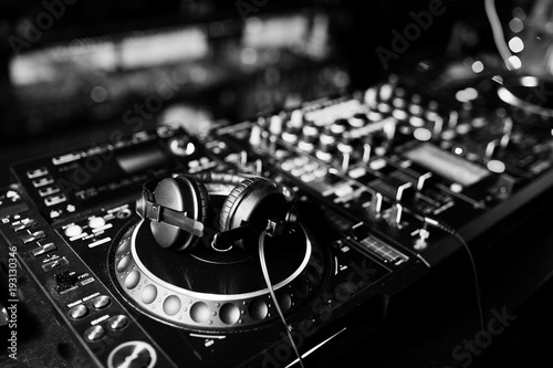 Photo  DJ spinning mixing and scratching track controls on dj's deck strobe