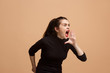 The young emotional angry woman screaming on pastel studio background