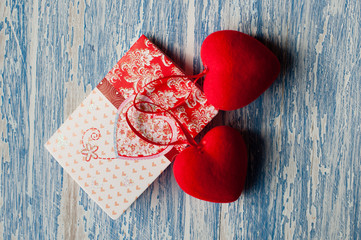 Valentine's day, background with space for copy. Postcard and red hearts on a wooden background