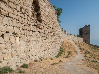 stone tower of an ancient fortress with adjoining rocky walls