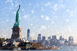 Fototapeta Nowy Jork - The Statue of Liberty free of tourists and New York City Downtown on sunny early morning during snowfall.