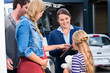 © Kzenon - Family being advised by salesperson in car dealership buying car