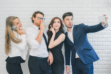 Professional business people happy and smiling, business team taking selfie by smartphone in the office