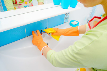 Wall Mural - Cleaning - cleaning bathroom sink and faucet with detergent in rubber gloves with sponge - housework, spring cleaning concept