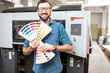 Funny portrait of typographer standing with color swatches at the printing manufacturing