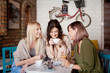 canvas print picture - Group of female friends having a coffee together. Three women at cafe, talking, laughing and enjoying their time. Lifestyle and friendship concepts with real people models.